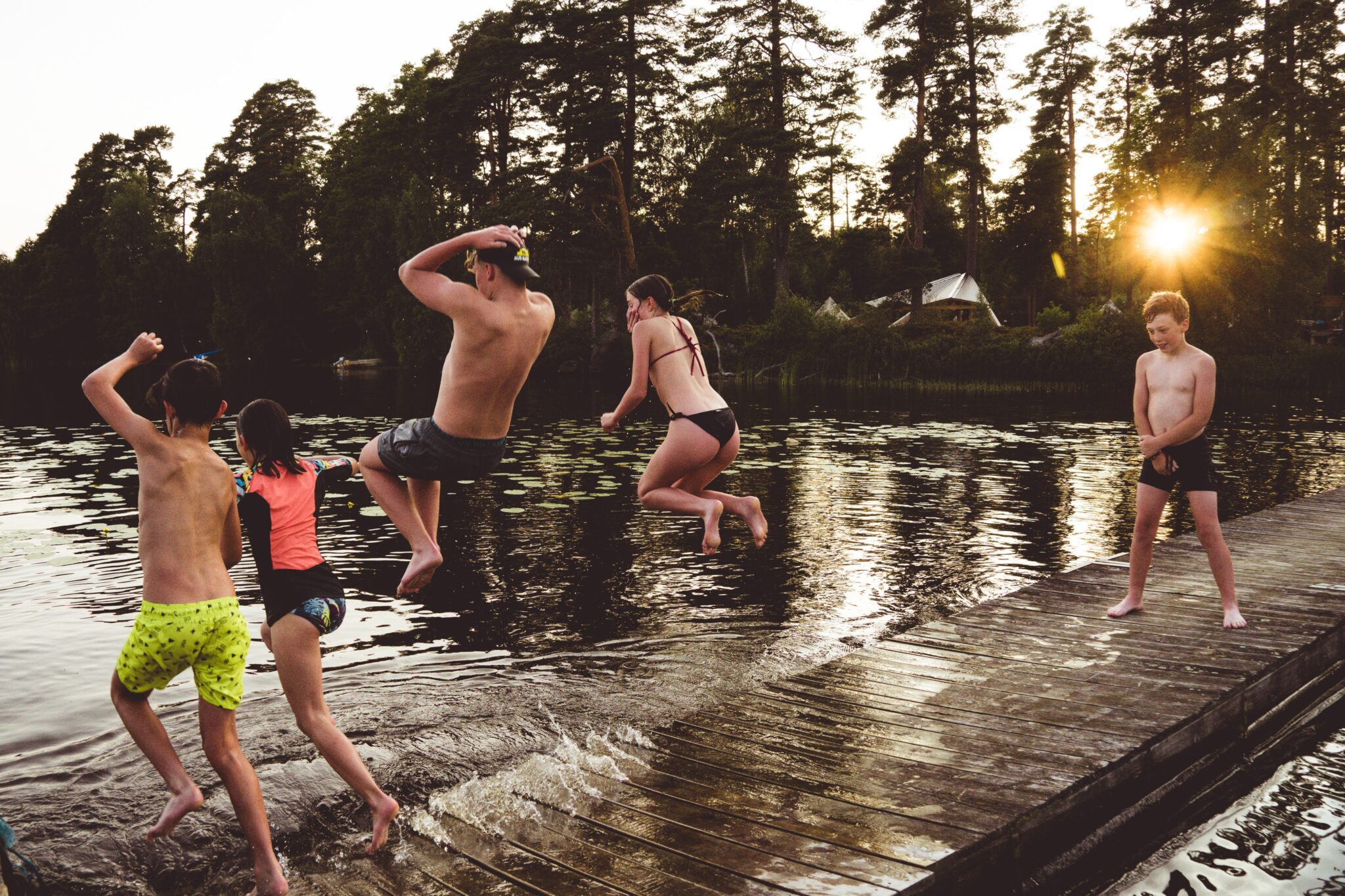 kinderen springen in het water - vakantie zweden - met kinderen op reis - kanotocht Zweden- reizen met kinderen