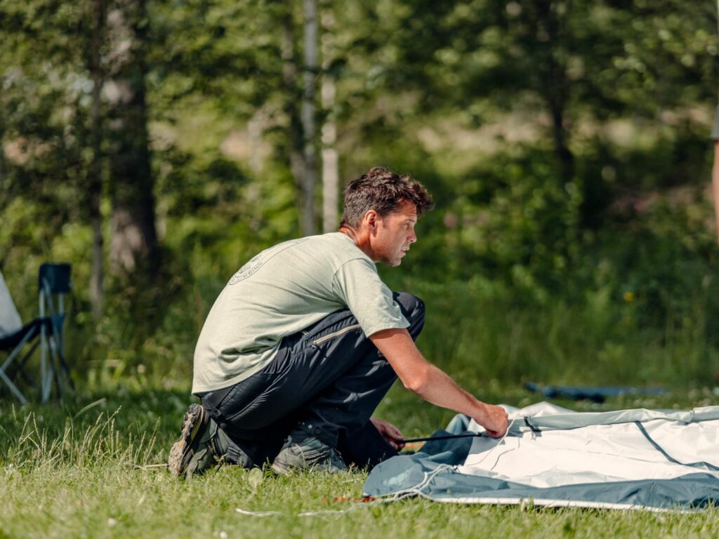 Man setting up a tent in Sweden - vakantie zweden - met kinderen op reis - kanotocht Zweden- reizen met kinderen