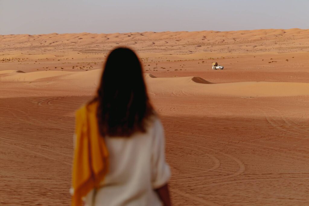 woman walking on the dunes in the Oman desert