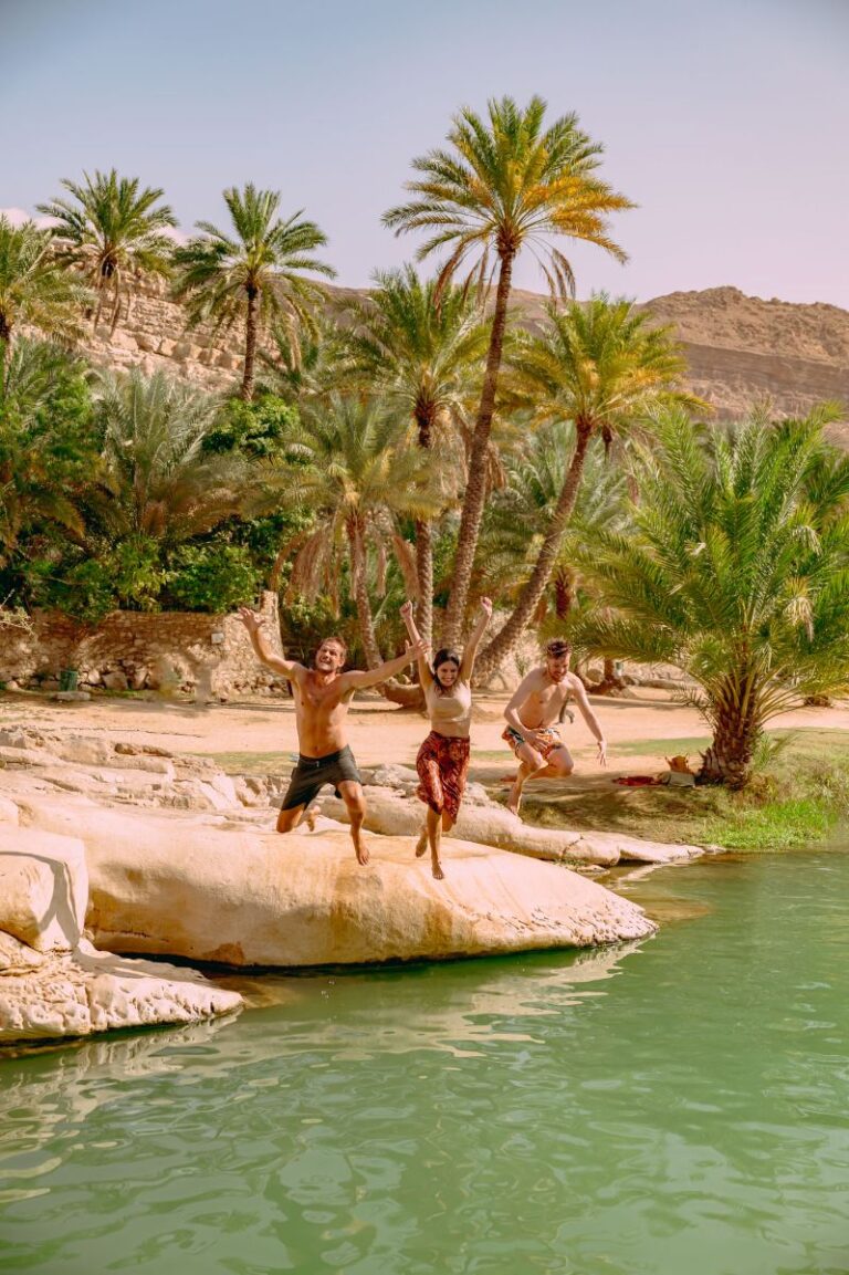 two people diving into a wadi in Oman