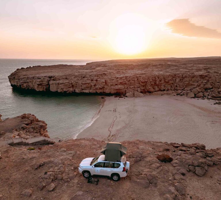 4x4 on top of a cove facing the ocean and the beach in Oman