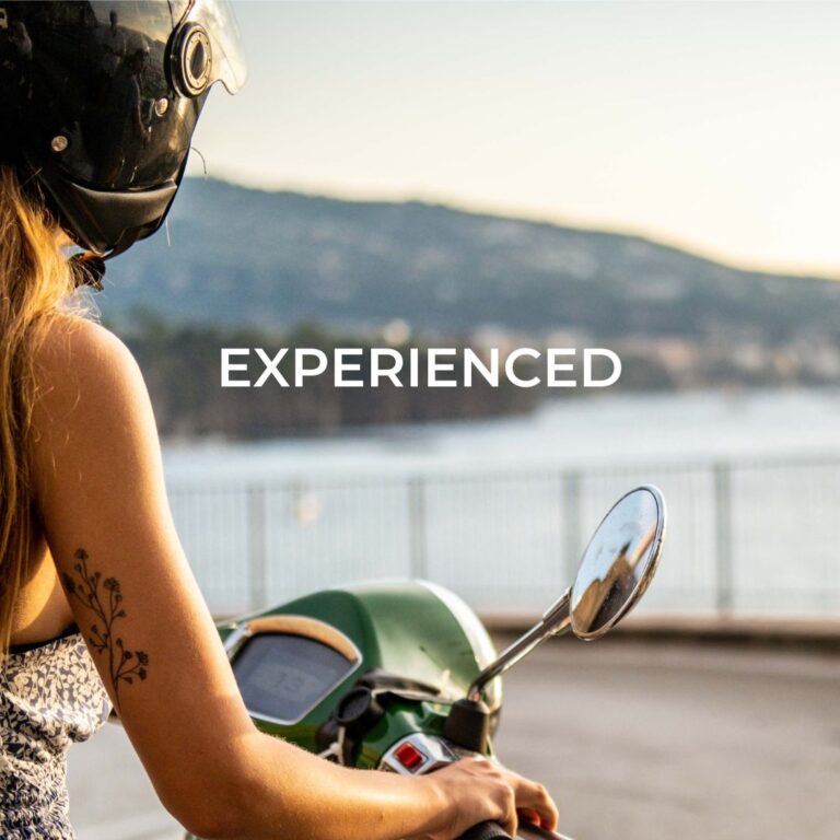 Abenteuerin auf ihrer Vespa in einer Kurve an der Amalfiküste – der perfekte Italien Roadtrip mit atemberaubender Aussicht.