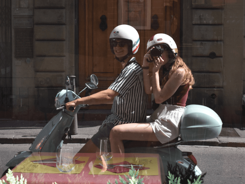 two people on a vespa mirror picture
