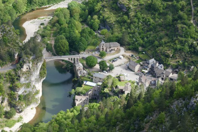 Luchtfoto van het middeleeuwse dorpje Saint-Chély-du-Tarn aan de rivier in de Gorges du Tarn, een rustige en groene kanoroute in Frankrijk.