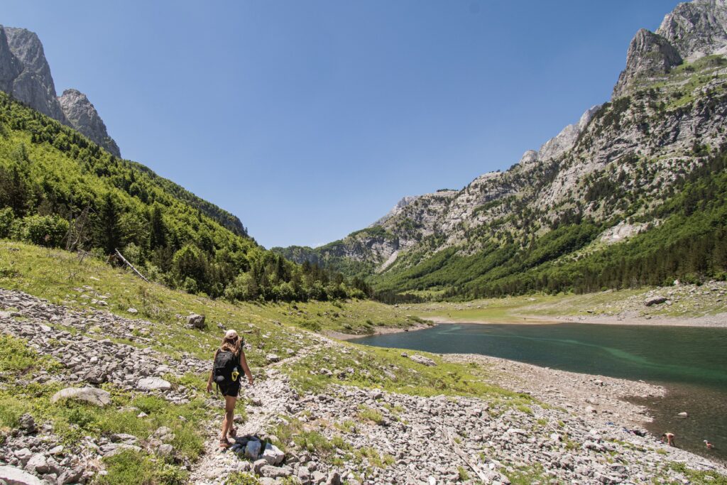 Wandelaar bij een meer in de Balkan Vusanje tijdens de Balkan Trail