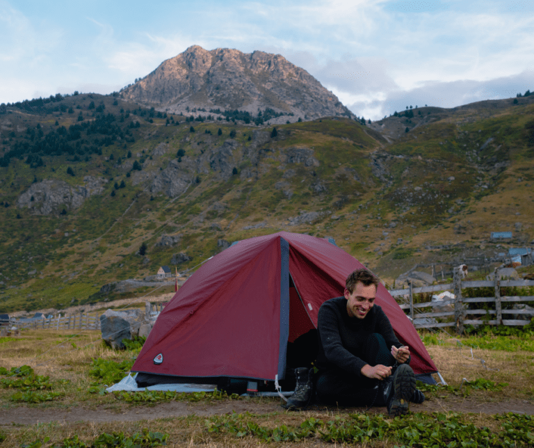 Randonneur devant sa tente pendant le trek dans les Balkans