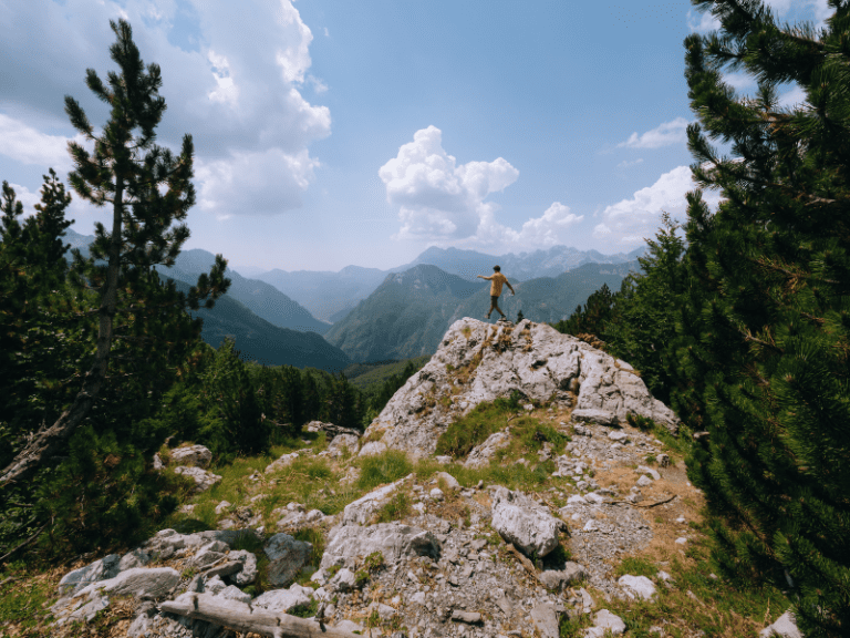 Wandelaar op een rots in Albanië Valbona-pas - Balkan Trail