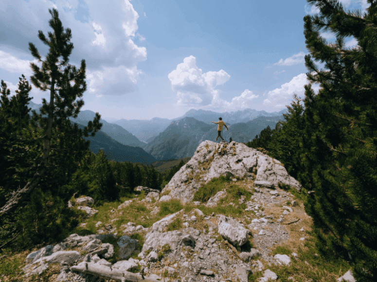 Wandelaar op een rots in Albanië Valbona-pas - Balkan Trail