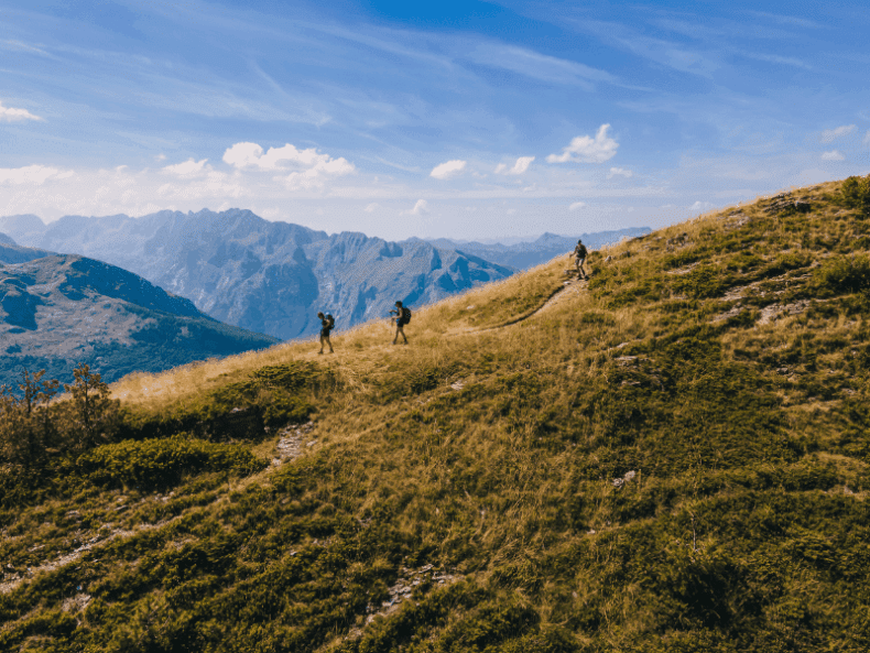 Drie wandelaars dalen de berg af richting Plav op de Balkanpieken - Albanië en Montenegro