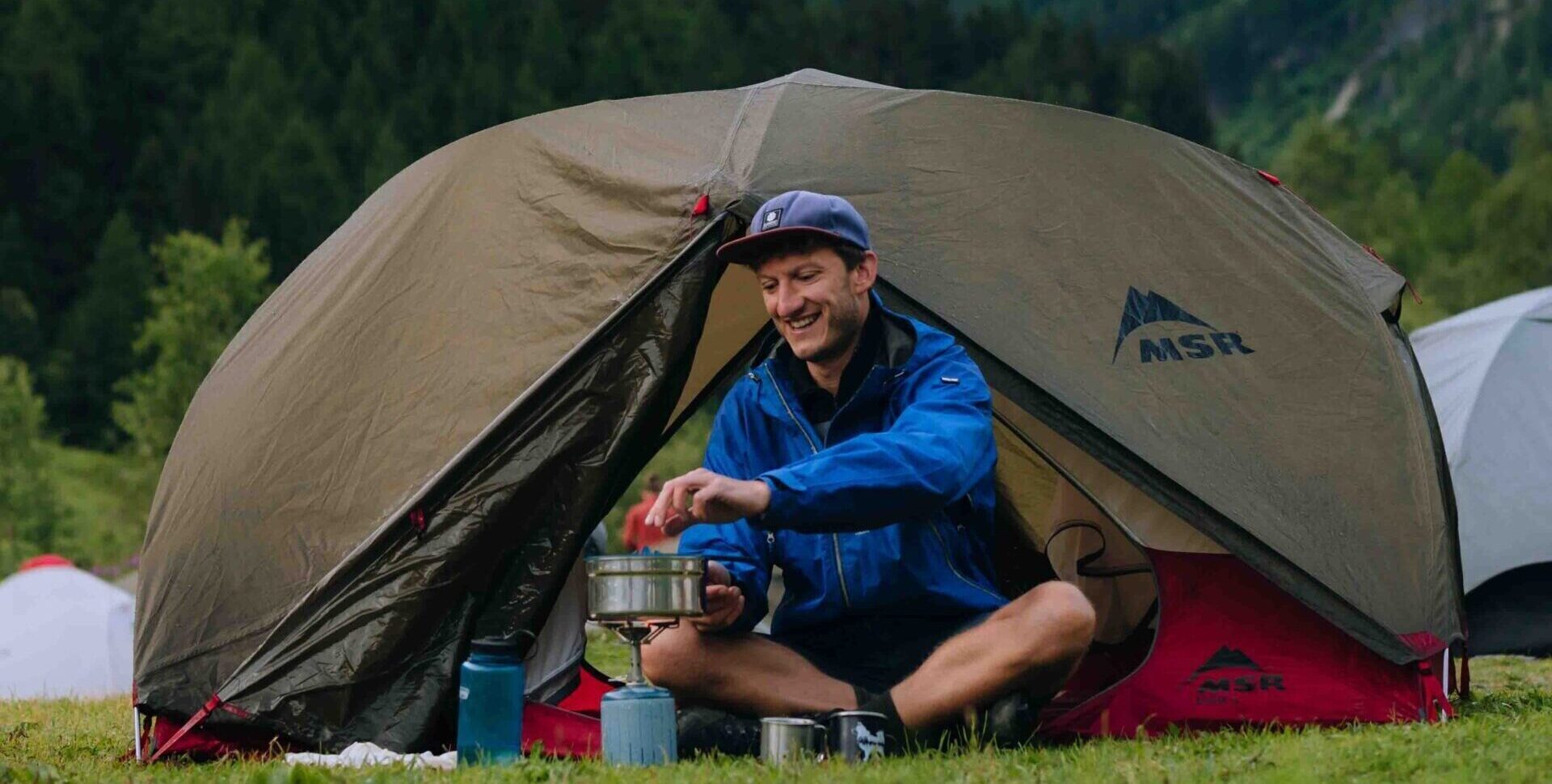 Randonneur en pause près de sa tente sur le MTB Mont Blanc Rundtour