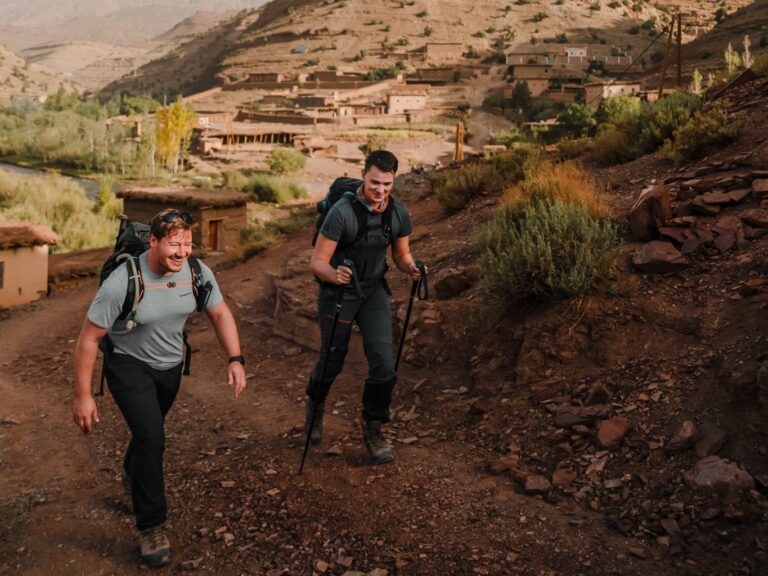 Deux randonneurs qui traversent un village dans le haut atlas au Maroc sur l'Atlas Trail