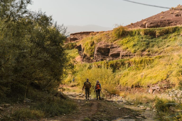 deux marcheurs au maroc qui traverse une vallée verte de l'Atlas